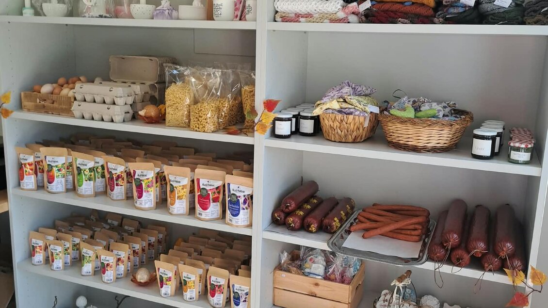 Ein Regal mit verschiedenen Handwerksartikeln und Kerzen. Auf den Regalen sind farbenfrohe Objekte, Kunstwerke und dekorative Artikel angeordnet. | © TV Gesäuse