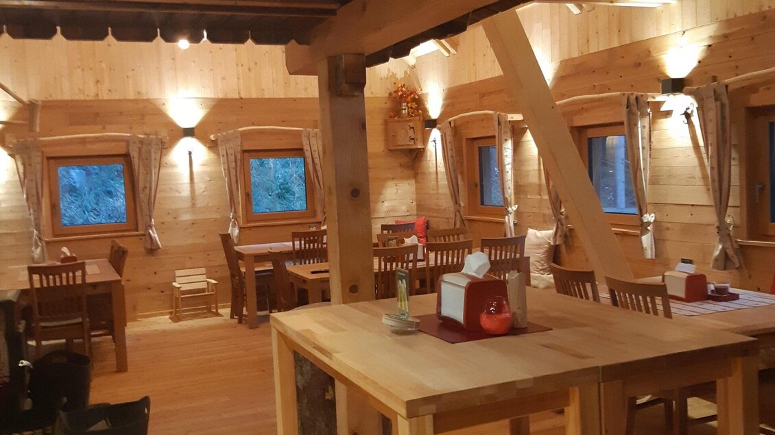 Ein gemütlicher Holzraum mit Tischen und Stühlen. Die Wände sind aus hellem Holz und es gibt Fenster, die schönes Licht hereinlassen. | © TV Erzberg Leoben