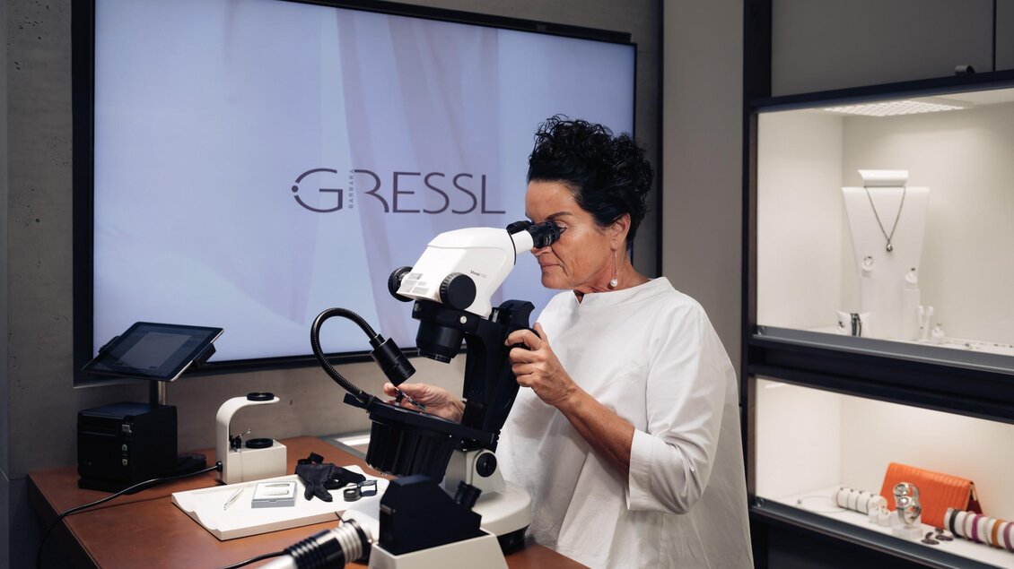 Frau Gressl untersucht einen Edelstein unter dem Mikroskop bei Juwelier Gressl. | © Bernd Grosseck