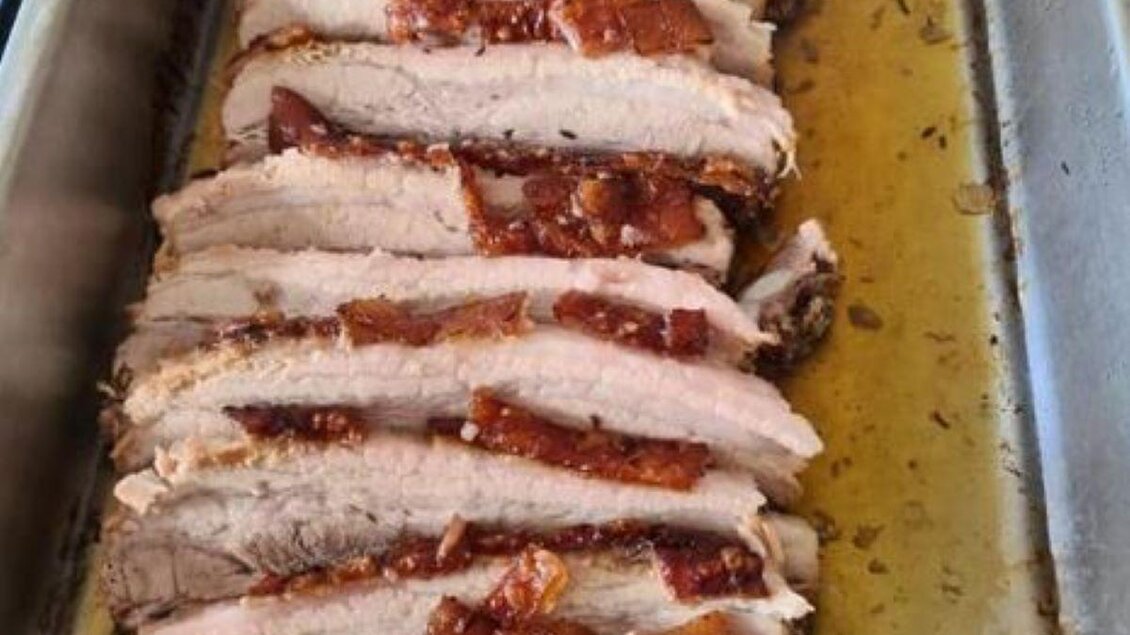 Zarte, in Scheiben geschnittene Fleischstücke mit knuspriger Kruste liegen in einer Auflaufform. Saftige Marinade umgibt das Fleisch. | © Köll Fleischfachgeschäft &amp; Catering