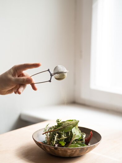 Frischer Salat mit grünem Blattgemüse in Schüssel, serviert im Kabuff Bistro & Restaurant in Graz auf hellem Tisch | © Kabuff