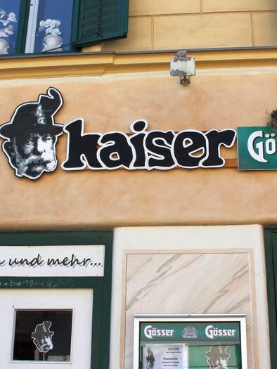 Die Kaiser BAR befindet sich direkt neben dem BILLA Supermarkt im Zentrum von Bad Aussee. Neben dem Namen vom Lokal befindet sich ein Schwarz-Weißes Porträt von Kaiser Franz Joseph über dem Eingang. | © TVB Ausseerland Salzkammergut