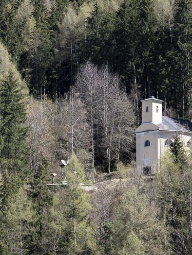 Eine kleine, weiße Kapelle steht zwischen dichten, grünen Wäldern. Die Umgebung ist ruhig und malerisch, ideal für Naturfreunde. | © Anita Fössl