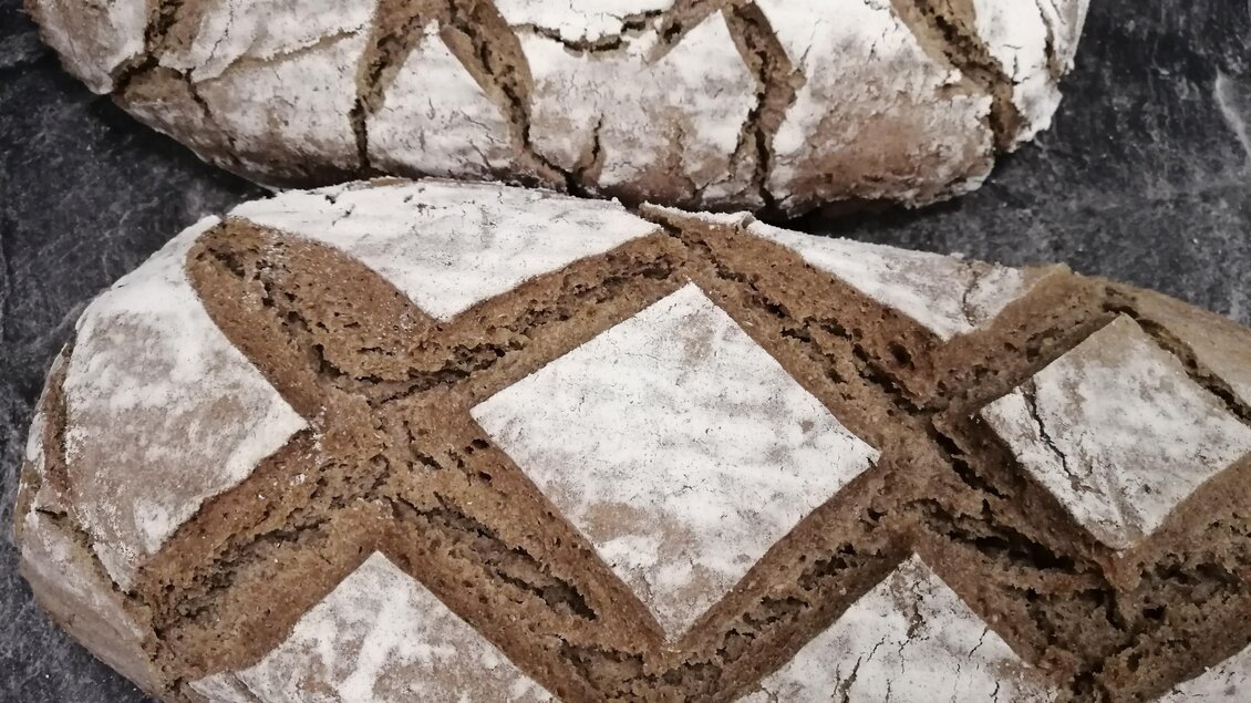 Zwei rustikale Brotlaibe mit bemehlter Kruste und kreuzförmigem Einschnitt aus Kathi’s Hofladen in Ligist | © Katharina Leitner