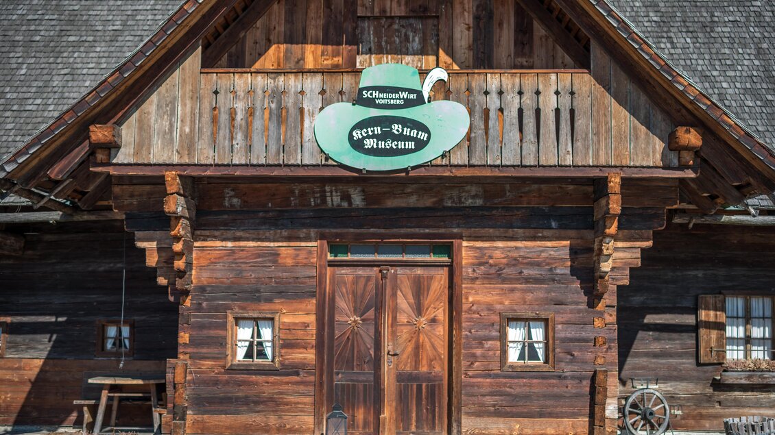 Eingang des Kern Buam Museums in einem historischen Holzgebäude mit Balkon und grünem Museumsschild in Voitsberg | © DieAbbilderei