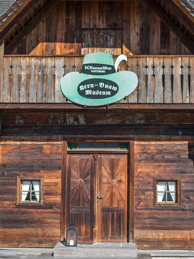 Eingang des Kern Buam Museums in einem historischen Holzgebäude mit Balkon und grünem Museumsschild in Voitsberg | © DieAbbilderei