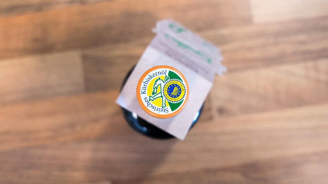 Eine Flasche mit einem Etikett, das das 10-jährige Jubiläum zeigt. Der Aufkleber hat ein buntes Design mit einem grünen Hintergrund. | © Michaela Lorber