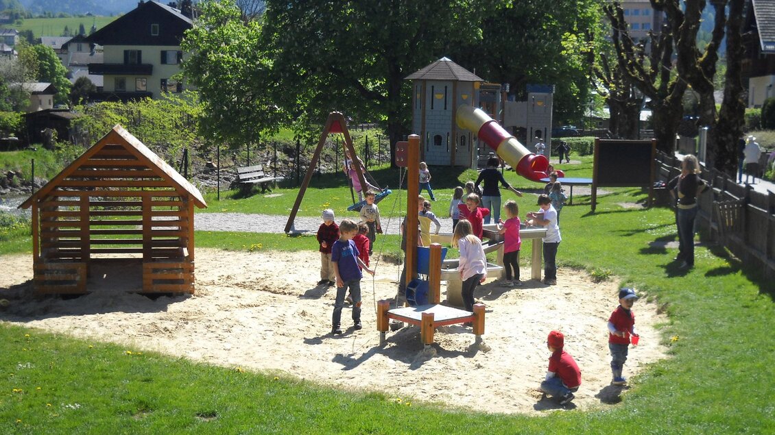 <p>Der Spielplatz bei der Elisabethpromenade in Bad Aussee mit vielen Kindern, die im Sand spielen. Es gibt eine Holzspielhütte und viele weitere Spielgeräte im Hintergrund.</p> | © Stadtgemeinde Bad Aussee