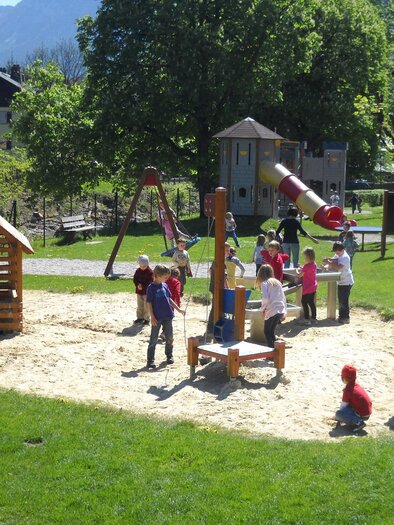 <p>Der Spielplatz bei der Elisabethpromenade in Bad Aussee mit vielen Kindern, die im Sand spielen. Es gibt eine Holzspielhütte und viele weitere Spielgeräte im Hintergrund.</p> | © Stadtgemeinde Bad Aussee