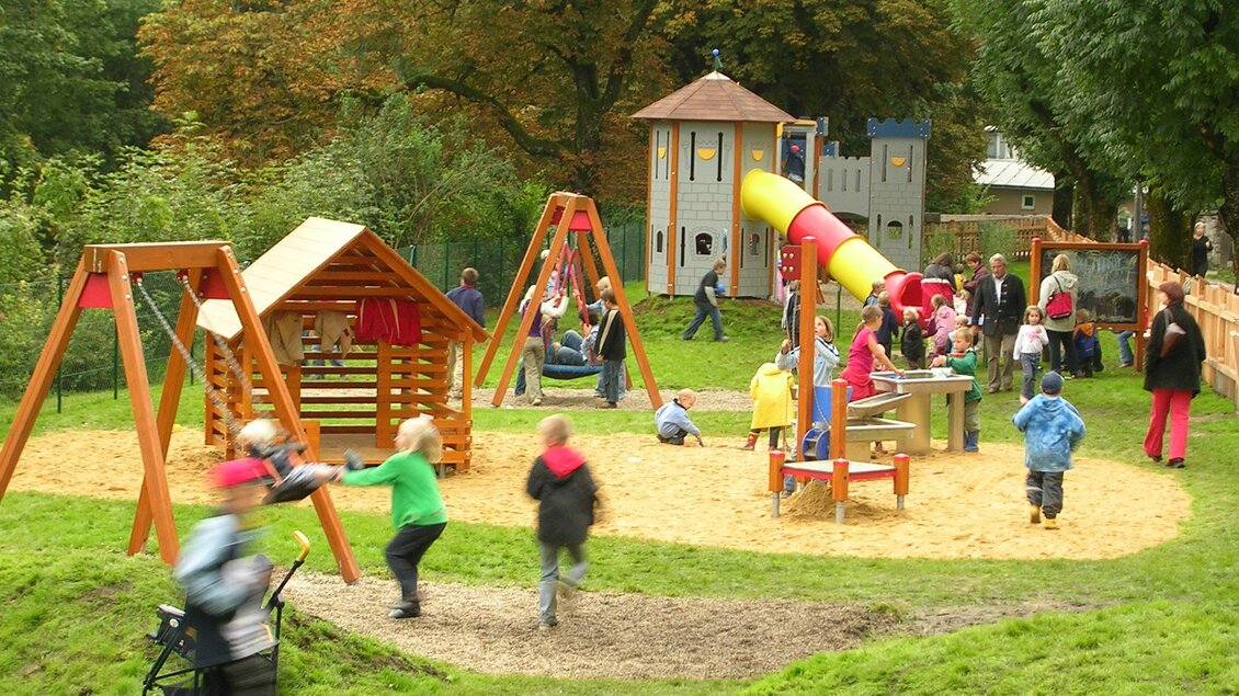 <p>Der Spielplatz bei der Elisabethpromenade in Bad Aussee mit verschiedenen Spielgeräten und vielen Kindern, die spielen. Im Hintergrund sind Bäume und eine Spieleburg zu sehen.</p> | © Stadtgemeinde Bad Aussee
