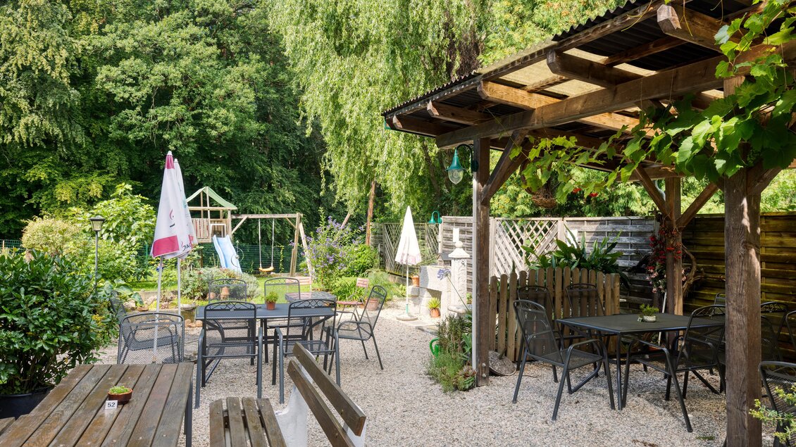 Ein schöner Garten mit Sitzgelegenheiten und einem Spielplatz im Hintergrund. Die Umgebung ist grün und einladend. | © Gasthof Durlacher