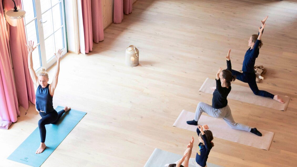 Eine Gruppe von Personen macht Yoga in einem hellen Raum. Die Atmosphäre ist entspannend und die Teilnehmer zeigen verschiedene Positionen. | © www.zloam.at