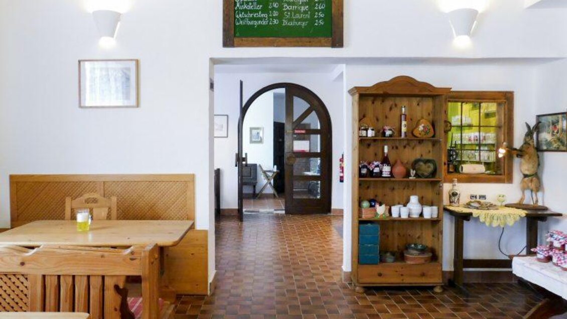 <p>Ein gemütliches Restaurant mit Holzmöbeln und einer einladenden Atmosphäre. Im Hintergrund sind Regale mit verschiedenen Gegenständen und eine Tafel mit Speisenangeboten zu sehen. Kleine Landküche in Bad Loipersdorf.</p> | © Familie Hradil