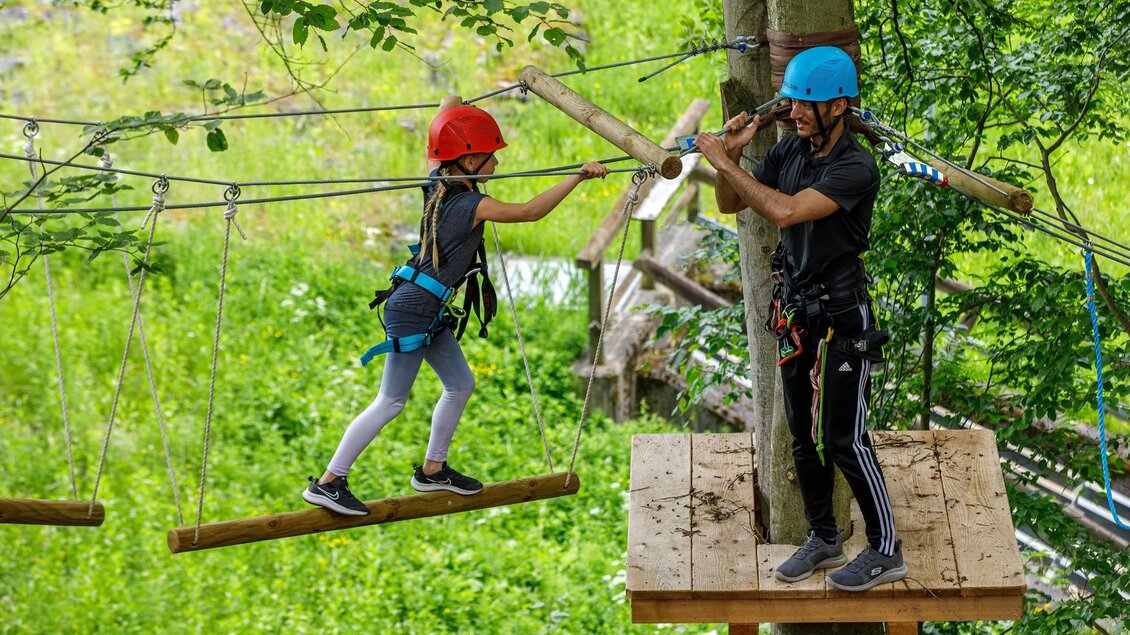 Zwei Personen im Kletterpark Piber balancieren auf Seilparcours im Wald mit Helm und Sicherung. | © Kletterpark Piber Eddy Aldrian