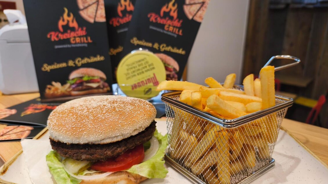 Ein köstlicher Hamburger mit Frischkäse und Salat, serviert auf einem Teller. Dazu gibt es knusprige Pommes frites in einem kleinen Korb. | © TVB Murau