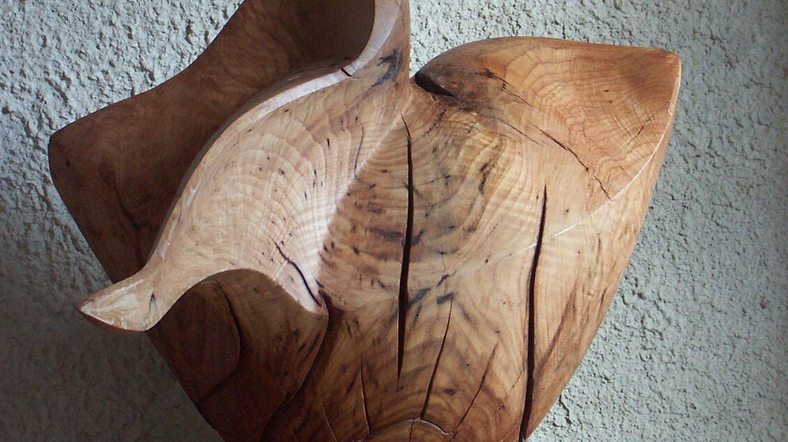 Eine kunstvolle Holzskulptur mit geschwungenen Formen. Die natürliche Maserung des Holzes verleiht dem Stück einen einzigartigen Charakter. | © Romana Leitner