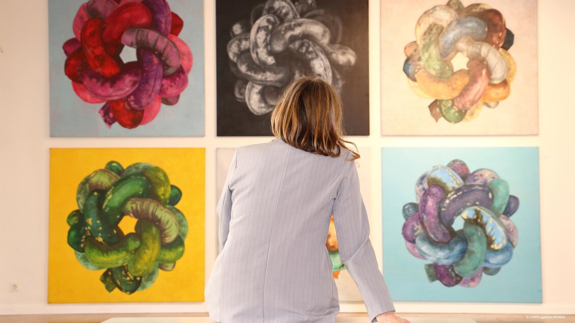 Person betrachtet farbige Kunstwerke an Wand im Kunsthaus Köflach, Ausstellung moderner Kunst in der Steiermark. | © FOTO agathon KOREN