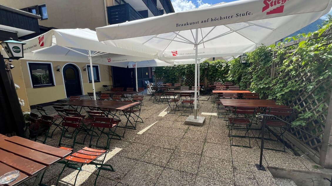 Der gemütliche Gastgarten vom Restaurant "La Marina" mit großen Schirmen sowie Tische und Stühle aus Holz. | © TVB Ausseerland Salzkammergut_Nathalie Schröttenhamer