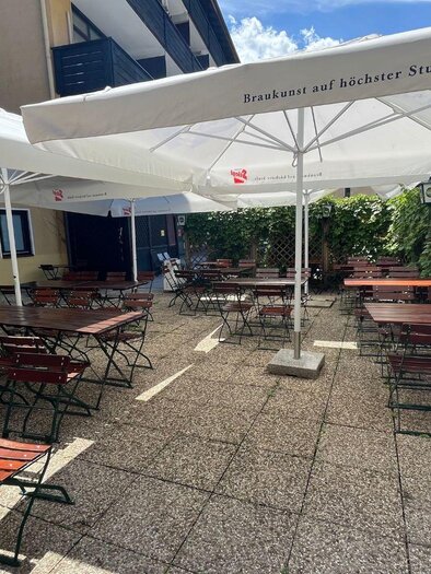 The cozy outdoor seating area of the restaurant "La Marina" with large umbrellas as well as tables and chairs made of wood. | © TVB Ausseerland Salzkammergut_Nathalie Schröttenhamer