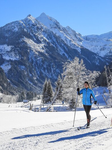 Zwei Personen, die im Winter Ski fahren, umgeben von verschneiten Bergen. Die Sonne scheint und der Himmel ist klar. | © Gerhard Pilz/Tourismusverband Schladming - Martin Huber