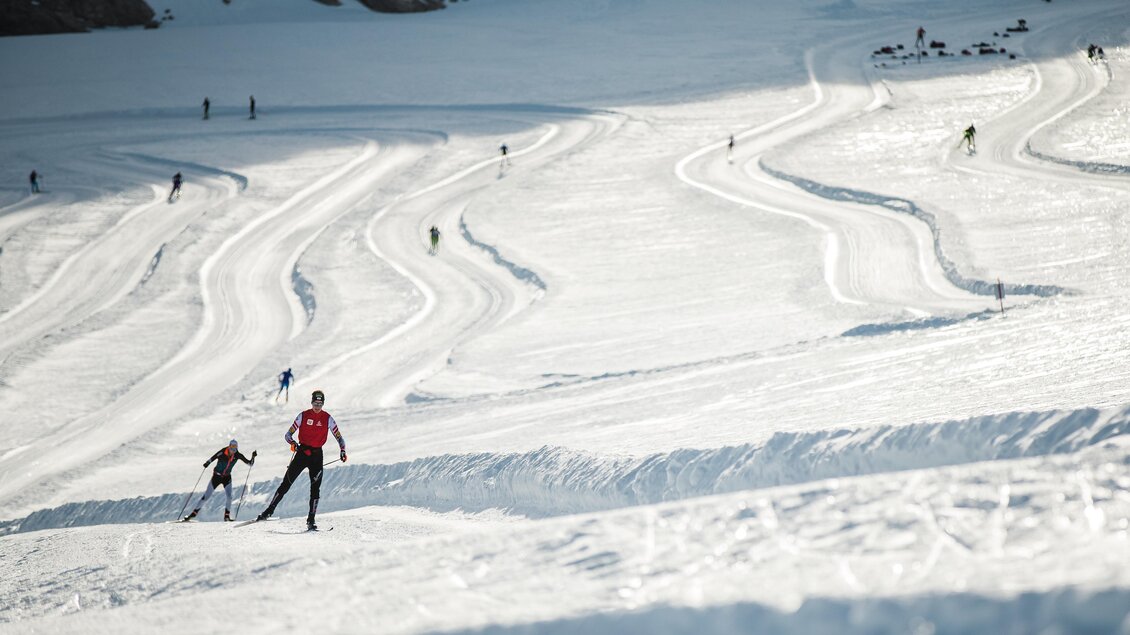 Eine verschneite Landschaft mit mehreren Skifahrern. Die Spuren im Schnee zeigen die Pisten und die Aktivitäten im Winter. | © Dominik Steiner