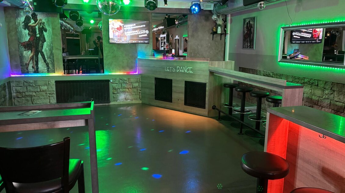 Eine moderne Bar mit bunten Lichtern und einer Tanzfläche. Die Sitzgelegenheiten sind elegant und die Atmosphäre ist einladend. | © Let's Dance/Rainer Kohlhauser