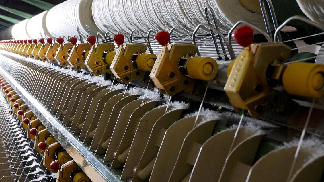 Eine moderne Spinnmaschine mit vielen Spulen und Fäden. Die Maschinen werden zur Textilherstellung verwendet. | © © 2021 Alwin Strasser - strasserconcept