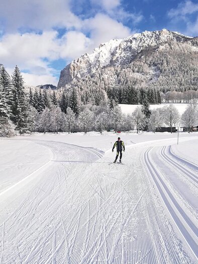 Eine schneebedeckte Landschaft mit einem beeindruckenden Berg im Hintergrund. Einige Menschen gehen auf einer verschneiten Fläche. | © Otto Rinnerhofer