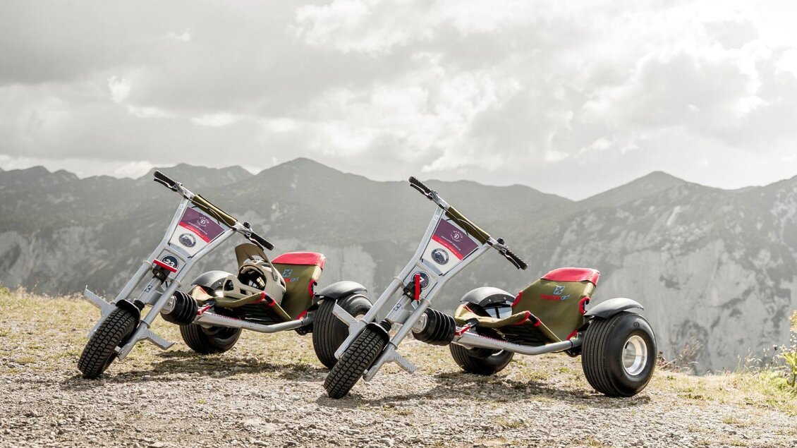 Zwei Mountaincarts der Loser Legends stehen hoch oben am Loser in Altaussee in der Nähe der Bergstation der Loser Panoramabahn. Im Hintergrund sind die Berge des Ausseerland Salzkammergutes zu sehen. | © Loser Legends - Mountaincart Salzkammergut