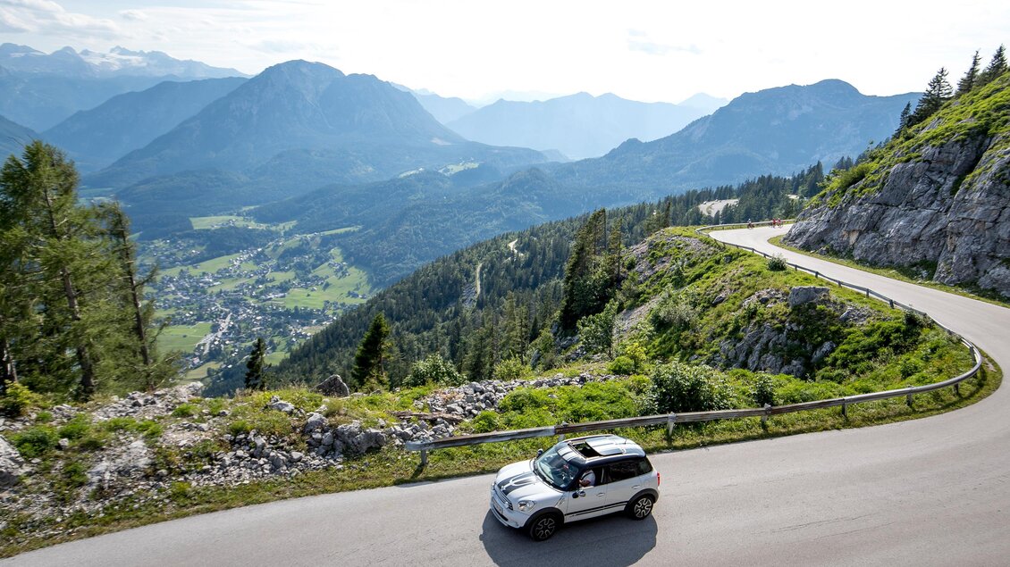 <p>Ein Auto fährt die Panoramastraße entlang den Loser hinauf. Im Hintergrund kann auf den Ort Altaussee hinunter gesehen werden.</p> | © TVB Ausseerland-Salzkammergut/Tom Lamm
