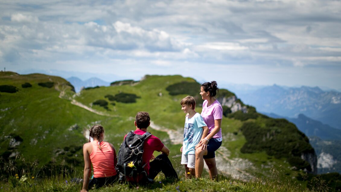 <p>Die Familie hat nicht mehr weit bis zum Losergipfel und macht gerade eine Pause von der Wanderung. Es ist ein sonniger Tag mit Wolken am Himmel.</p> | © TVB Ausseerland-Salzkammergut/Tom Lamm