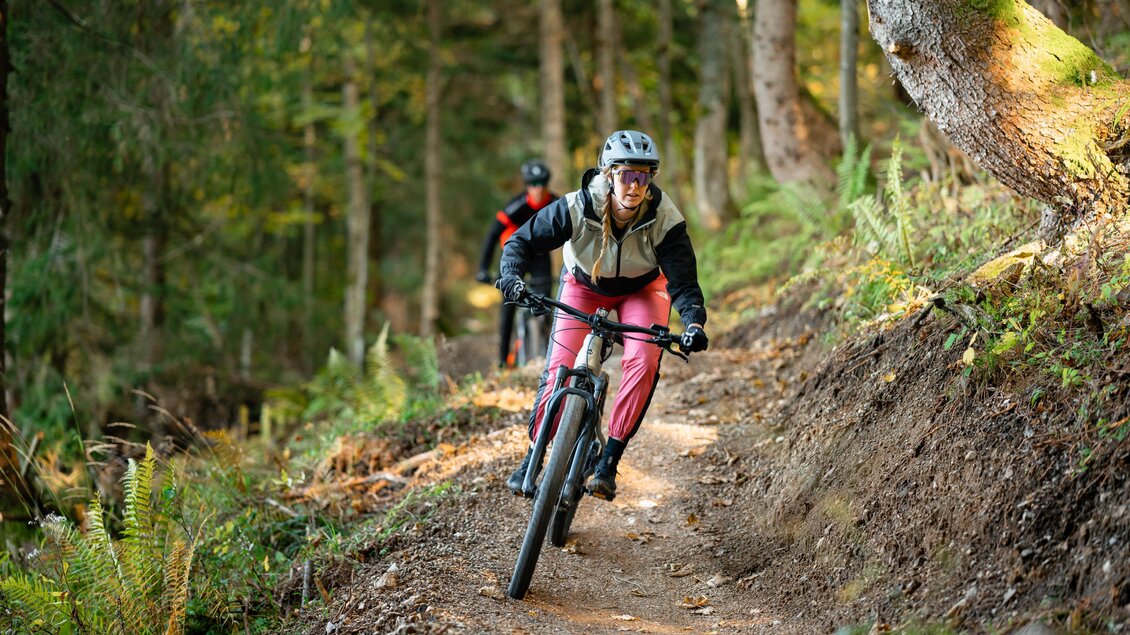 <p>Eine Radfahrerin fährt mit ihrem Mountainbike auf einem schmalen Weg am Augst Trail durch den grünen Wald am Loser in Altaussee.</p> | © Loser Bergbahnen Altaussee/K. Steinegger