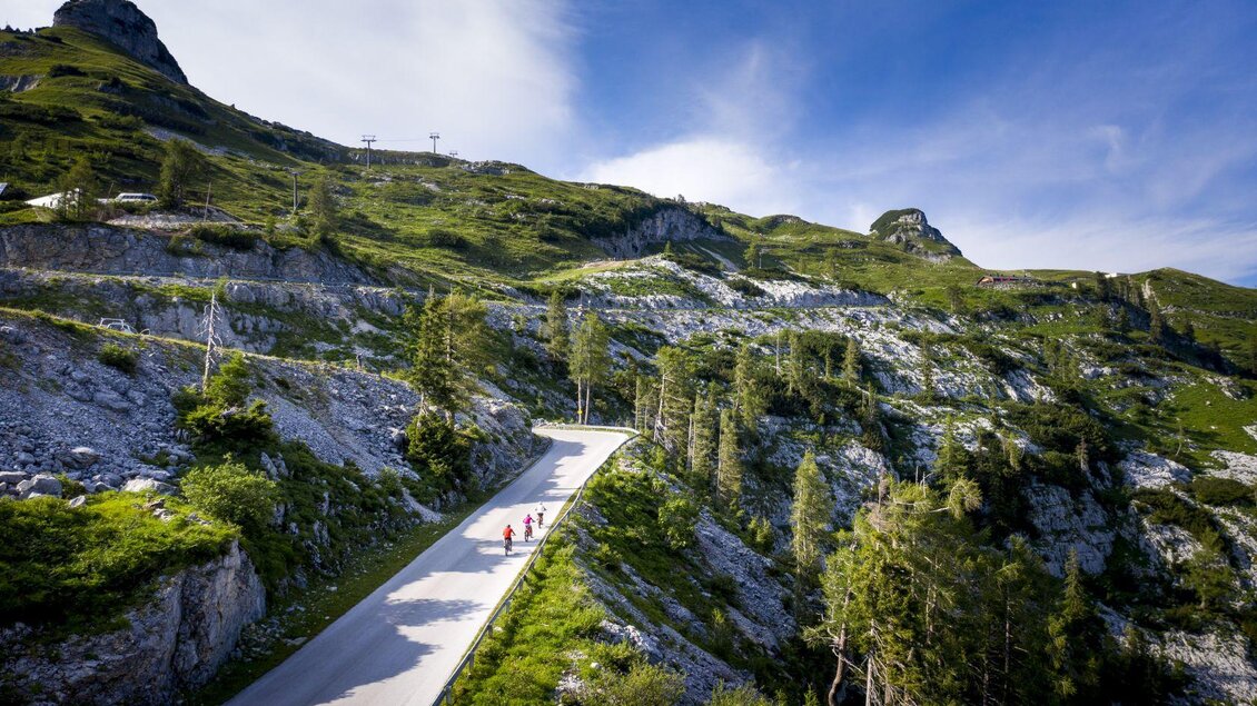 <p>Die drei Radfahrer haben noch ein paar Kurven vor sich, bevor sie über die Panoramastraße die Loseralm erreichen. Grüne Wiesen und Felsen umgeben die Straße.</p> | © TVB Ausseerland - Salzkammergut-Tom Lamm