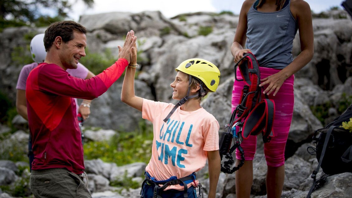 <p>Eine Gruppe von Kletterern ist bereit für das Klettern beim Klettersteig Sophie am Loser. Ein Erwachsener und ein Kind geben sich einen High-Five, während andere sich auf das Klettern vorbereiten.</p> | © TVB Ausseerland - Salzkammergut-Tom Lamm