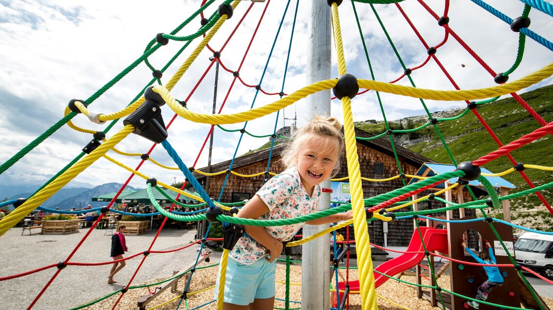 <p>Ein Kind spielt auf einem bunten Klettergerüst neben der Loseralm in Altaussee. Im Hintergrund sind noch weitere Klettergerüste und eine schöne Landschaft zu sehen.</p> | © TVB Ausseerland-Salzkammergut/Tom Lamm