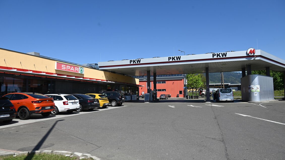 Eine Tankstelle mit mehreren Autos und einem Supermarkt in der Nähe. Der Himmel ist klar und blau. | © M-Rast