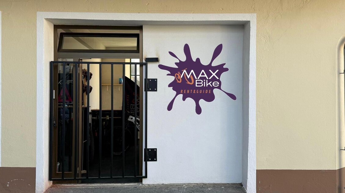Der Eingang eines Geschäfts mit dem Namen "MAX Bike" ist durch ein schwarzes Gittertor gesichert. Die Wand ist in hellem Farbton gestrichen und zeigt ein buntes Logo. | © Markus Kaltenegger