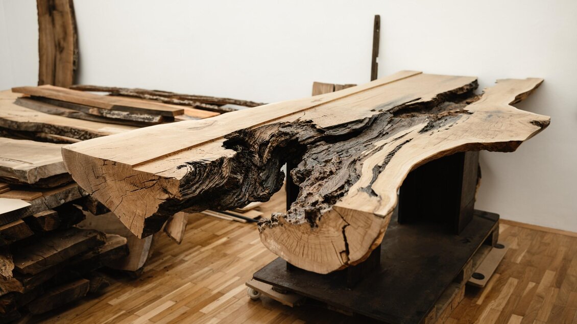 Massiver Baumstamm mit natürlicher Kante und markanter Maserung liegt im MORI Atelier zur Verarbeitung bereit. | © Bernd Grosseck