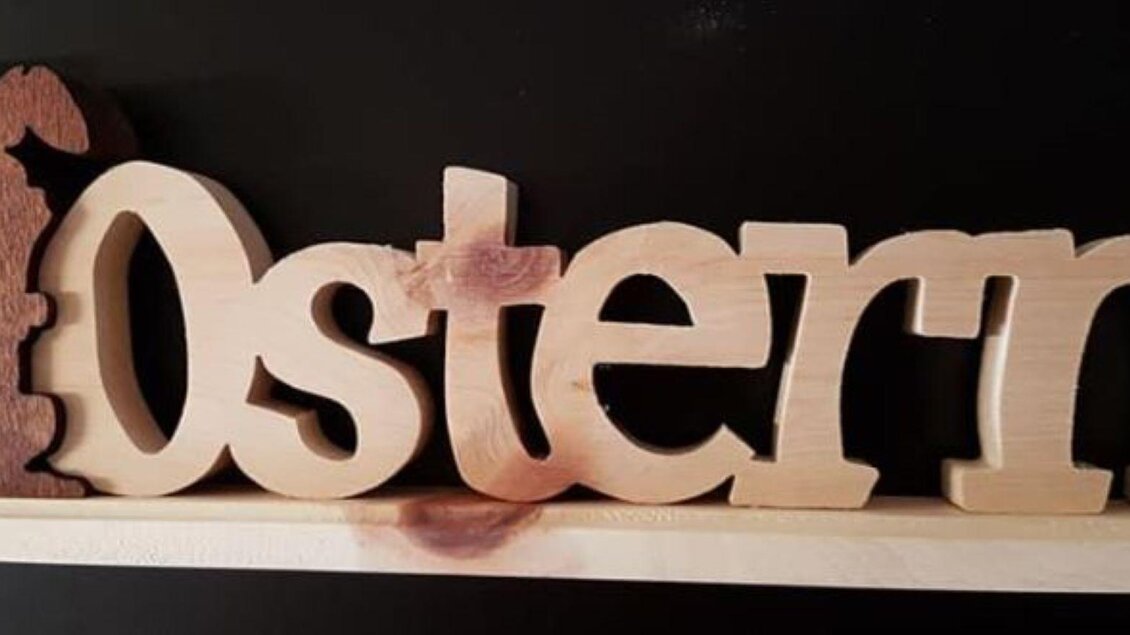 Ein dekoratives Holzschild mit der Aufschrift "Ostern" und einem Hasen. Das Schild hat eine helle Holzfarbe und strahlt eine festliche Stimmung aus. | © Oskar Stieg