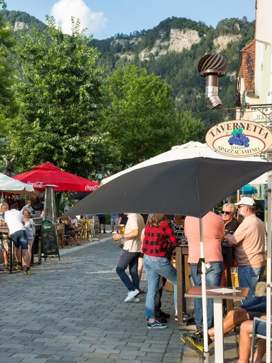 Guests enjoy drinks in the sunshine in front of the Tavernetta Dallo Spazzacamino restaurant in Frohnleiten. | © TV Region Graz - René Vidalli