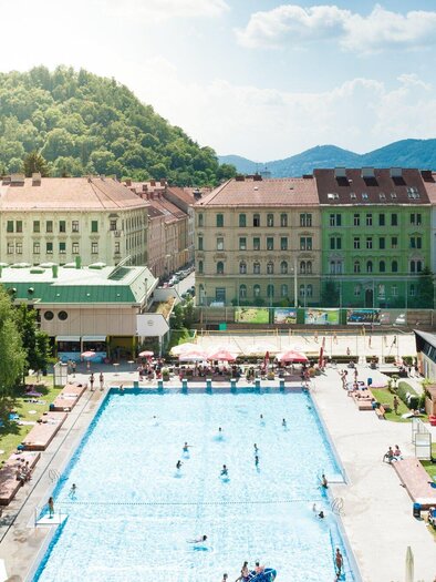 Das Margaretenbad im Stadtzentrum von Graz umgeben von Wohngebäuden. Menschen genießen die Sonne und das Wasser. | © Holding Graz - Joel Kernasenko