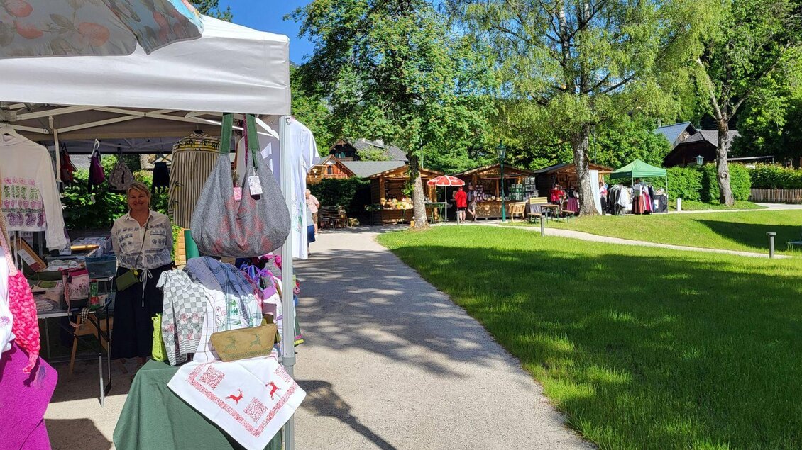 <p>Ein lebhafter Markt im Kurpark Altaussee mit verschiedenen Ständen und grüner Umgebung. Besucher schlendern auf einem gepflasterten Weg zwischen den Ständen.</p> | © Petra Kirchschlager