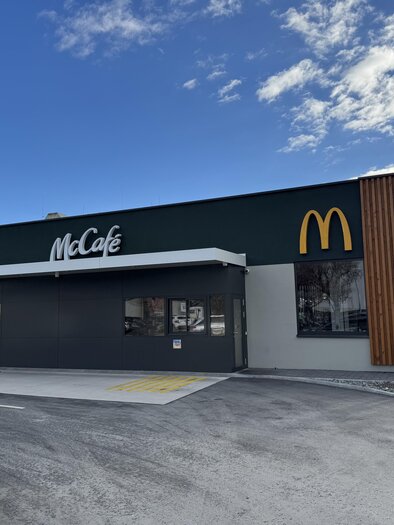 A modern McDonald's restaurant with a McCafé façade. The surroundings are bright and friendly, with a blue sky in the background. | © TV Hochsteiermark