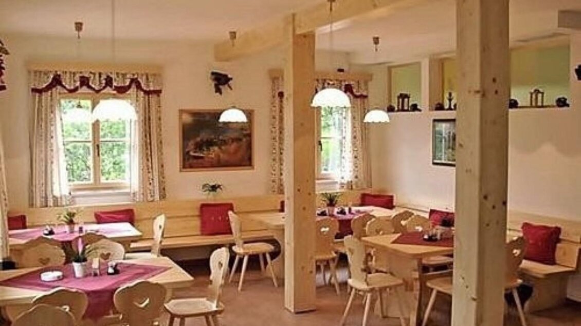 Ein gemütliches Restaurant mit Holzmöbeln und runden Tischen. Die Wände sind hell und mit Fenstern sowie Dekorationen geschmückt. | © Mostschenke Ressenstüberl