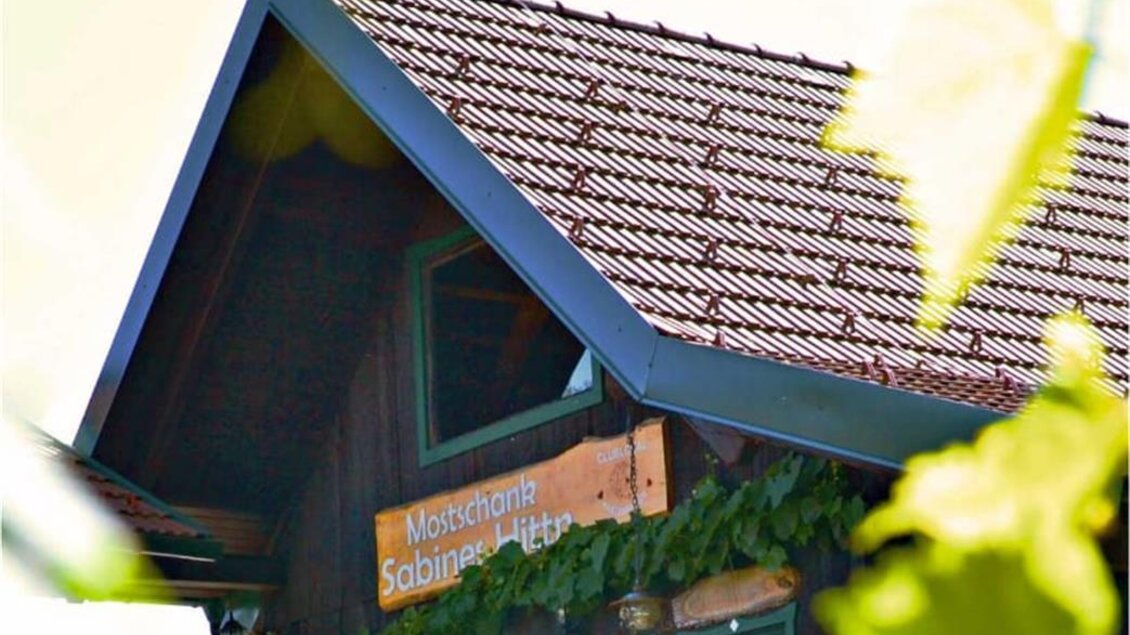 Ein gemütliches Restaurant mit dem Namen "Mostschank Sabines Hitt'n". Es ist von Pflanzen umgeben und hat eine einladende Atmosphäre. | © Mostschank Sabiens Hitt´n