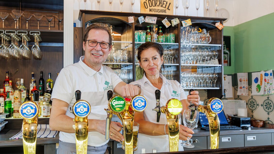 Wirt und Wirtin vom MurWirt Gössendorf beim Bierausschank hinter der Theke. | © Region Graz-Harry Schiffer