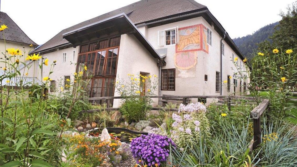 Ein charmantes Haus mit einer blühenden Gartenlandschaft. Bunte Blumen und eine ruhige Atmosphäre umgeben das Gebäude. | © Handwerksmuseum Murau