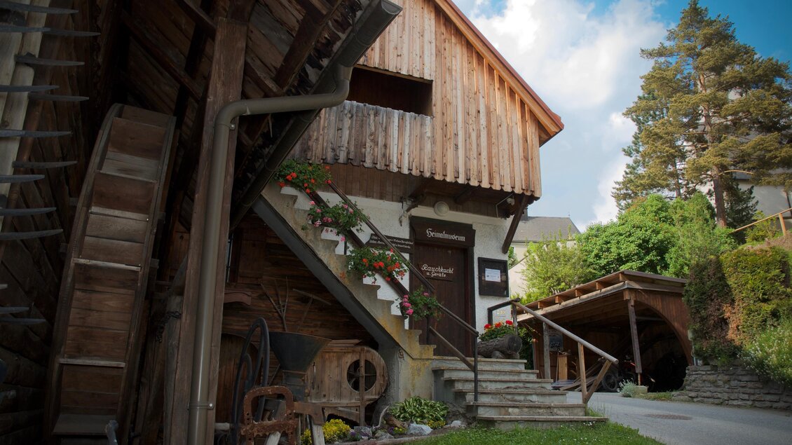 Ein rustikales Holzhaus mit einer Treppe und grüner Umgebung. Der Himmel ist klar und die Atmosphäre ist einladend. | © TV ERZBERG LEOBEN
