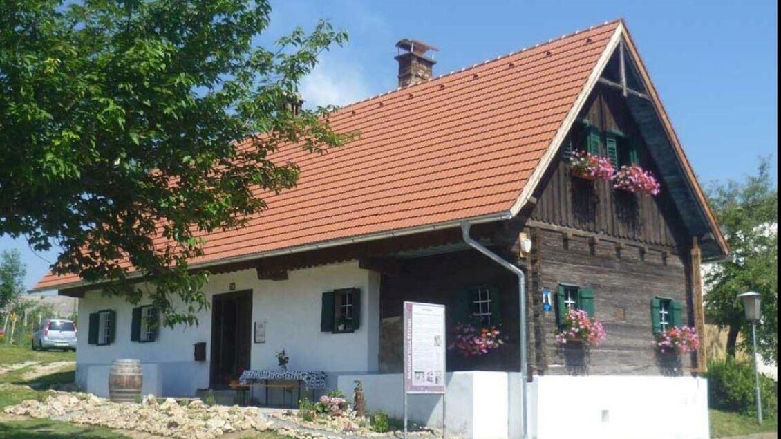 Ein traditionelles Schweizer Haus mit einem roten Satteldach und grünen Fensterläden. Blumen schmücken die Fenster, und die Umgebung ist grün und einladend. | © Museum Villa Retznei