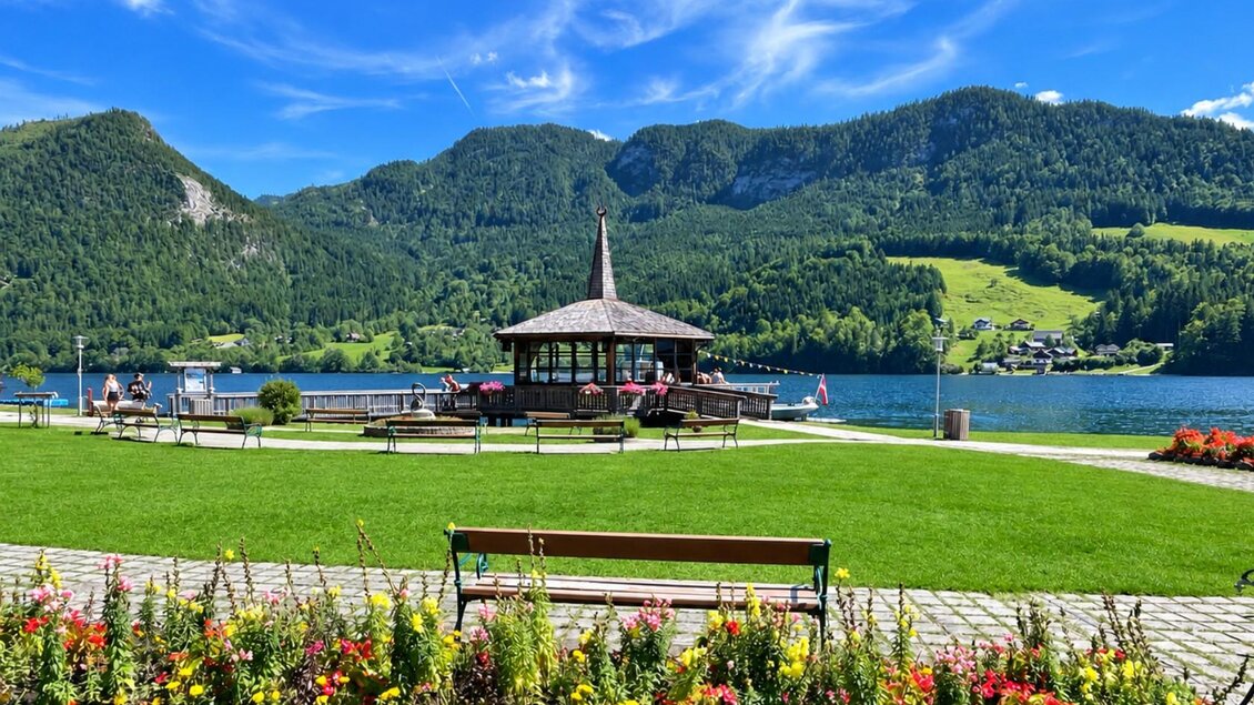 Ein malerischer See mit einem Pavillon und grünen Wiesen. Im Hintergrund sind Berge und ein klarer blauer Himmel zu sehen. | © Tourismusverband Ausseerland